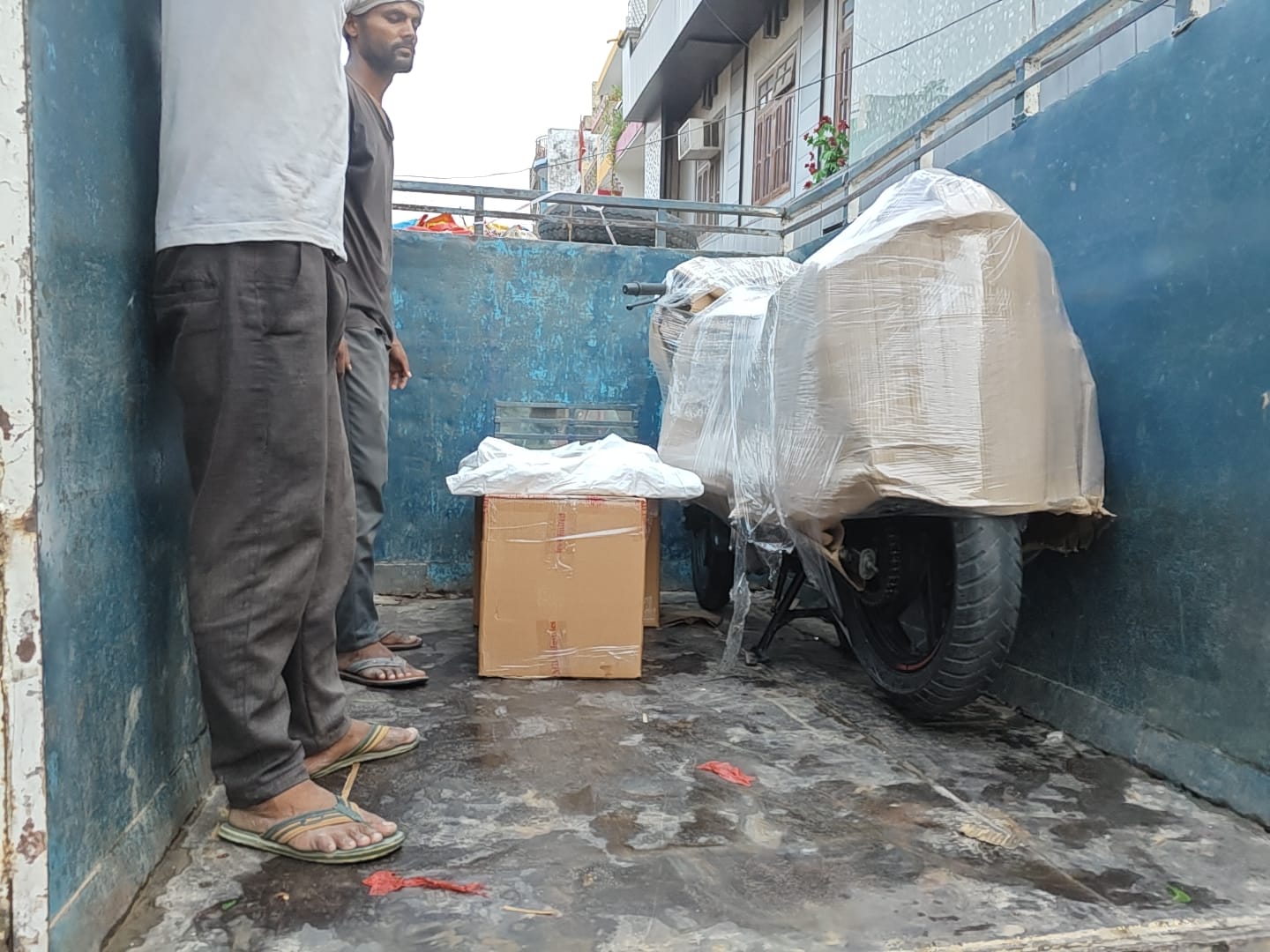 Workers safely loading packed bike and boxes into a transport truck