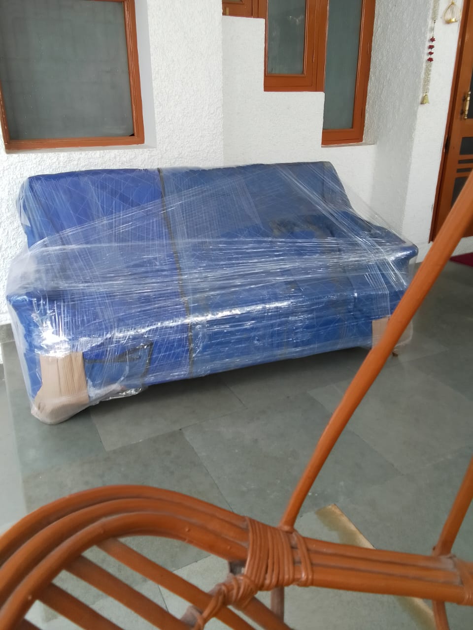 Sofa wrapped securely in blue plastic stretch wrap for local shifting